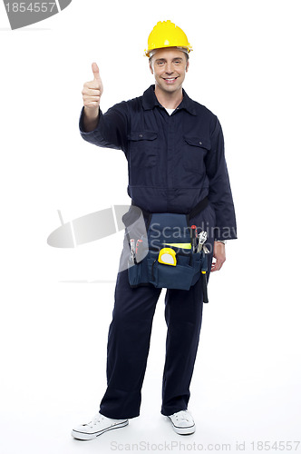 Image of Young smiling industrial engineer showing thumbs up