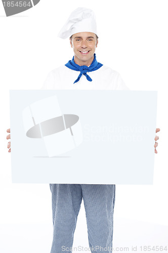 Image of Handsome male chef holding ad board