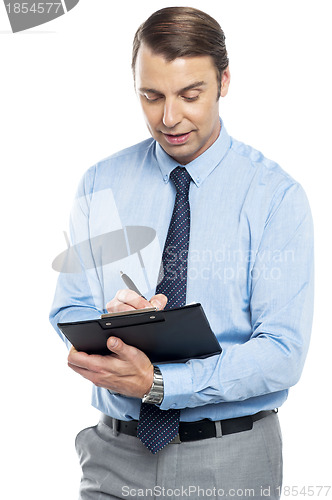 Image of Male secretary taking down notes given by boss