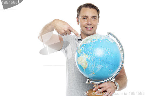 Image of Man holding globe and pointing over it