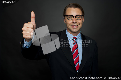 Image of Businessman showing thumbs up sign to his team