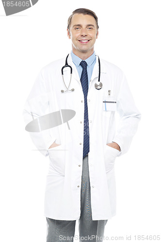 Image of Young doctor posing with hands in his overcoat