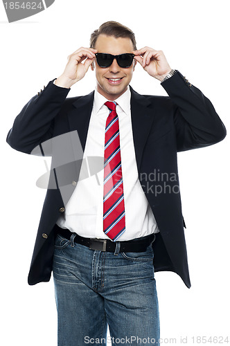 Image of Young business achiever holding shades in style