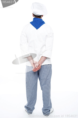 Image of Rear view of male chef posing with hands behind