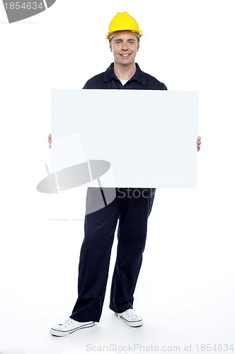 Image of Repairman holding blank billboard, full length portrait