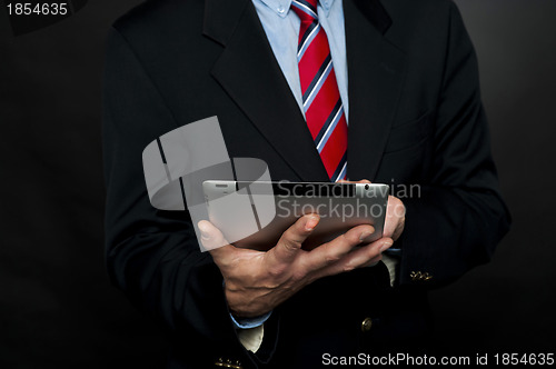 Image of Cropped image of businessman browsing tablet pc