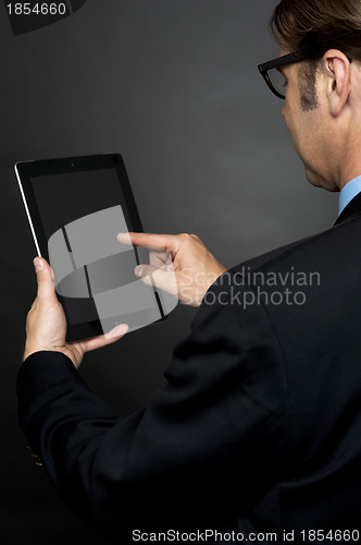 Image of Rear view of boss browsing on new tablet pc