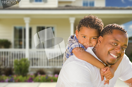 Image of Mixed Race Father and Son In Front of House