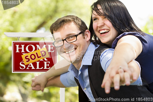 Image of Happy Couple in Front of Sold Real Estate Sign