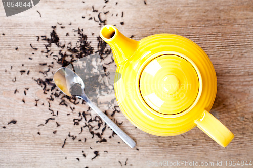 Image of yellow teapot with spoon and tea 