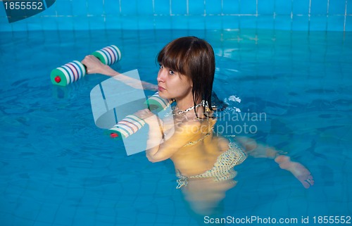 Image of Attractive girl trains in aqua aerobics