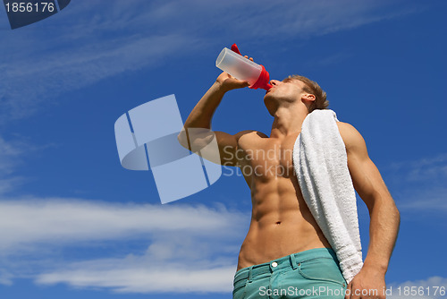 Image of Fit young man drinking water