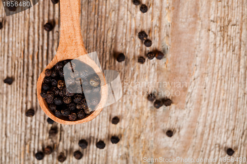 Image of black peper in wooden spoon 