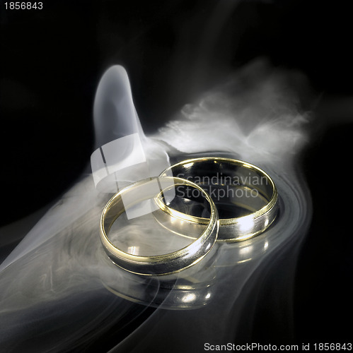 Image of golden wedding rings and smoke