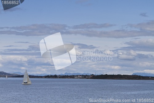 Image of coastline with singel sailing boat in norway