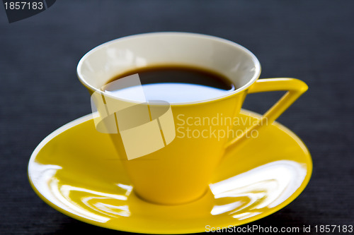 Image of Black coffee in yellow cup and saucer