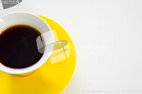 Image of Black coffee in yellow cup and saucer