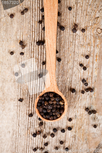 Image of black pepper in wooden spoon