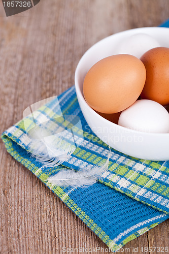 Image of eggs in a bowl, towel and feathers