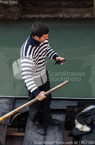 Image of Gondolier Checking his Mobile Phone