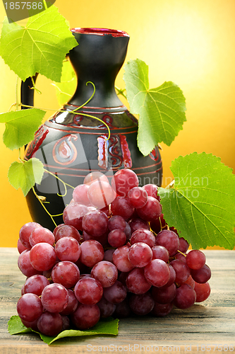 Image of Pitcher and bunch of grapes.