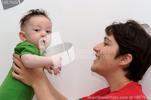 Image of Cute baby held by his smiling mother looks toward the camera