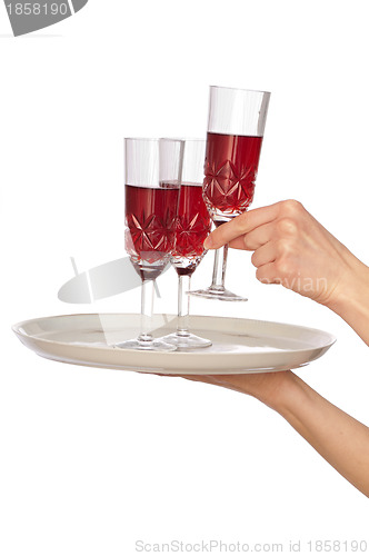 Image of waiter carrying glasses with red wine