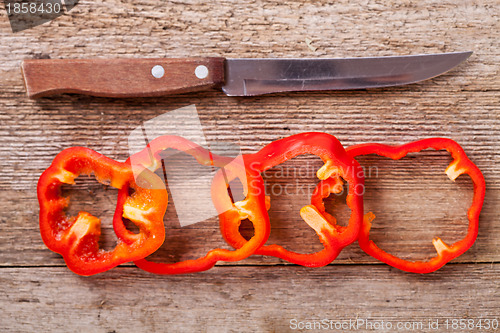Image of sliced red bell peppers and old knife