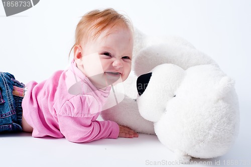 Image of Baby girl with bear toy