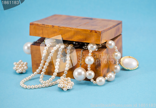 Image of Pearl jewelry defocus in retro wooden box on blue 