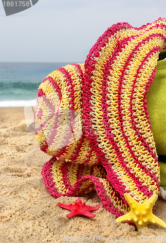 Image of Green beach bag, pink straw hat and funny sea stars