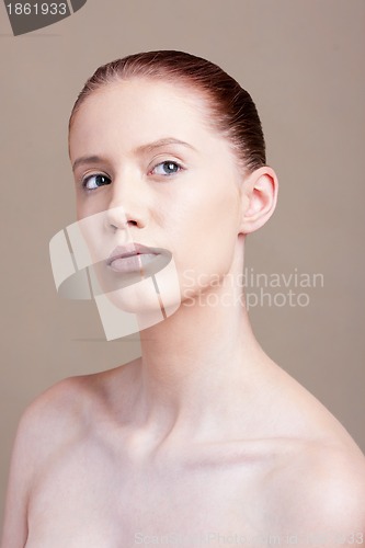 Image of Portrait of young beautiful woman with clear make-up over brown background 