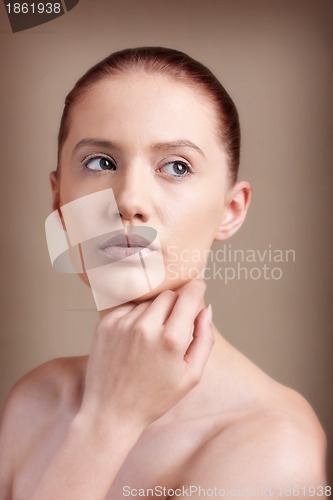 Image of Portrait of young beautiful woman with clear make-up over brown background 
