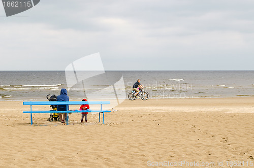 Image of woman with kid sit on bench bicycle sea coast line 