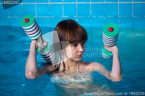 Image of Pretty girl doing aqua aerobic exercise