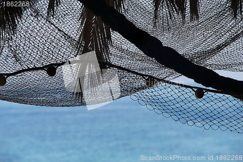 Image of View of morning sea with palm tree silhouettes and fishing nets