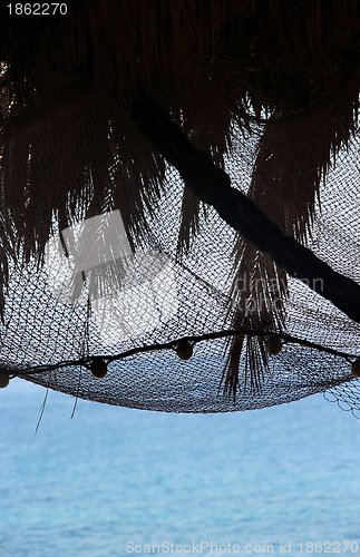 Image of View of morning sea with palm tree silhouettes and fishing nets