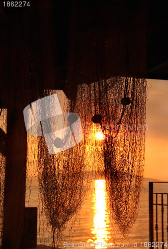 Image of Wonderful sea sunset with palm tree silhouettes and fishing nets