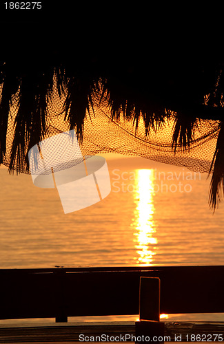 Image of Wonderful sea sunset with palm tree silhouettes and fishing nets