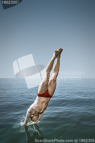 Image of man jumping in the lake
