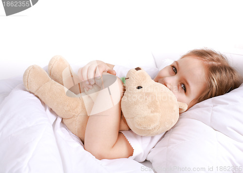 Image of Cute girl cuddling with teddy bear