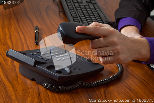 Image of Businessman replacing telephone receiver