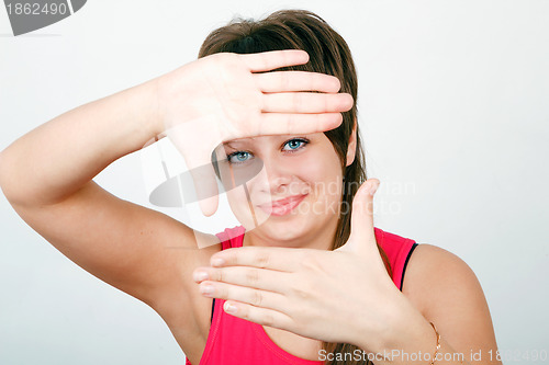 Image of girl looks through a framework of hands 
