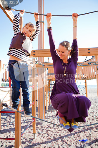 Image of Mother and son playing at playground.