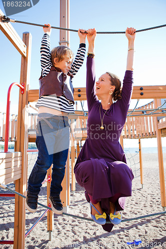 Image of Mother and son playing at playground.