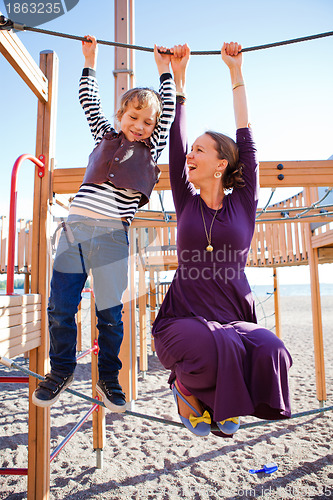 Image of Mother and son playing at playground.