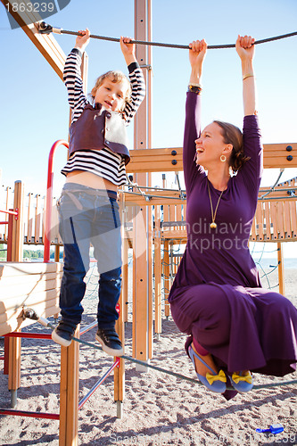 Image of Mother and son playing at playground.