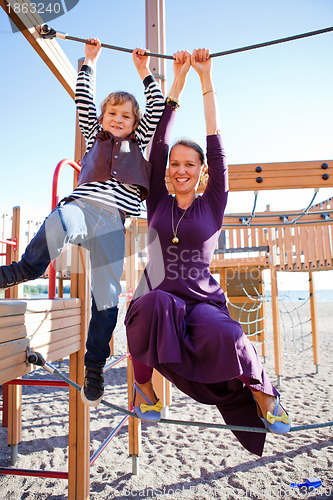 Image of Mother and son playing at playground.