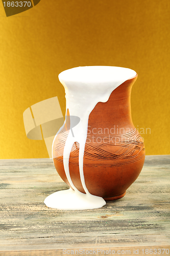 Image of Ceramic jug overflowing cream.