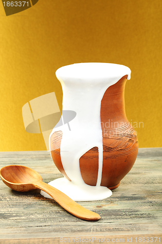 Image of Clay pot with cream and spoon.